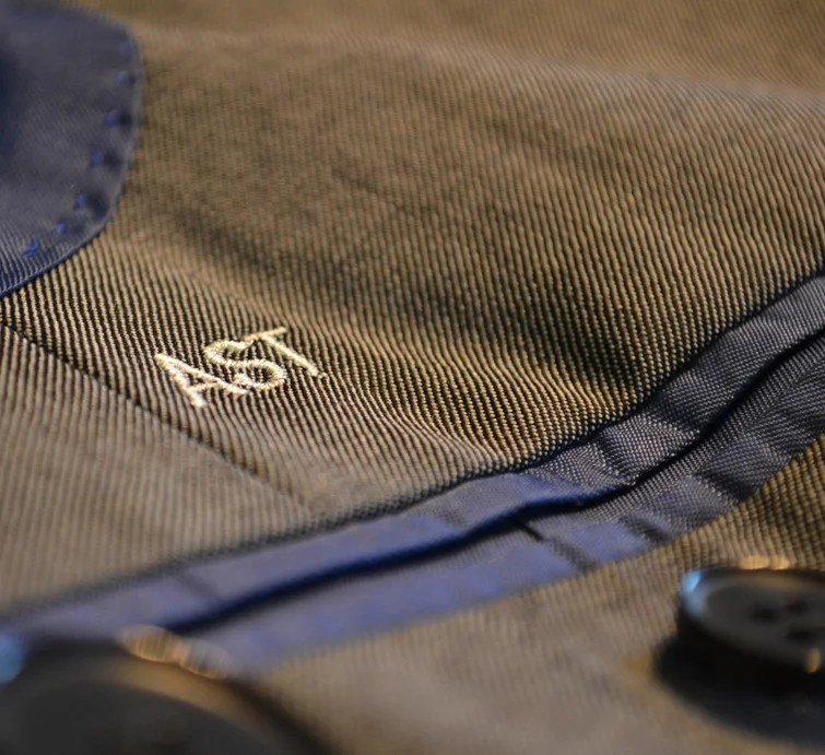Hand-embroidered VJ monogram on a bespoke garment
